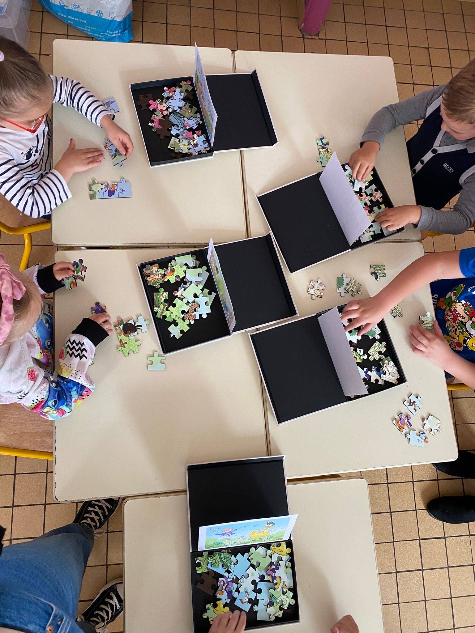 Les enfants réalisent un puzzle lors de l'atelier sur table.